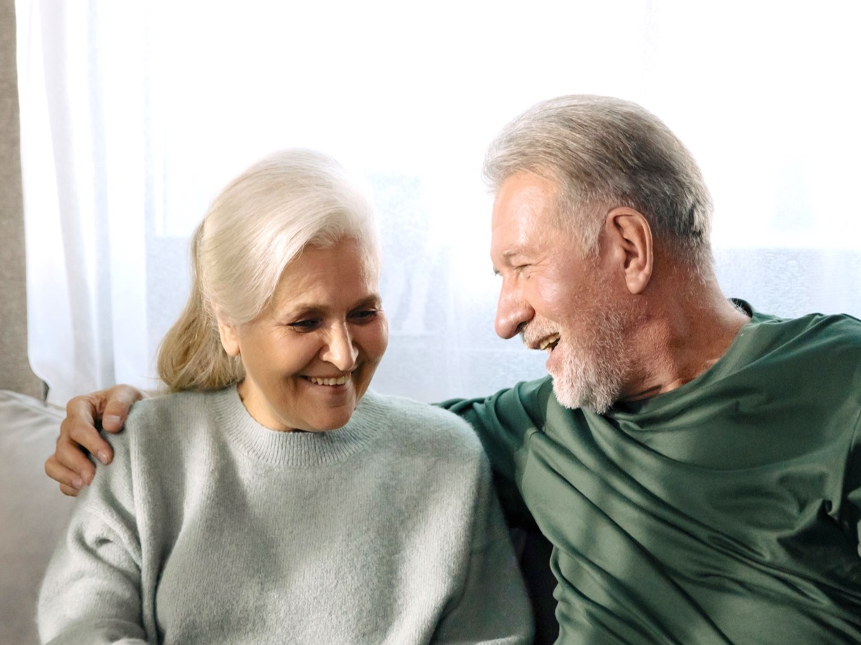 A senior couple smiling at each other
